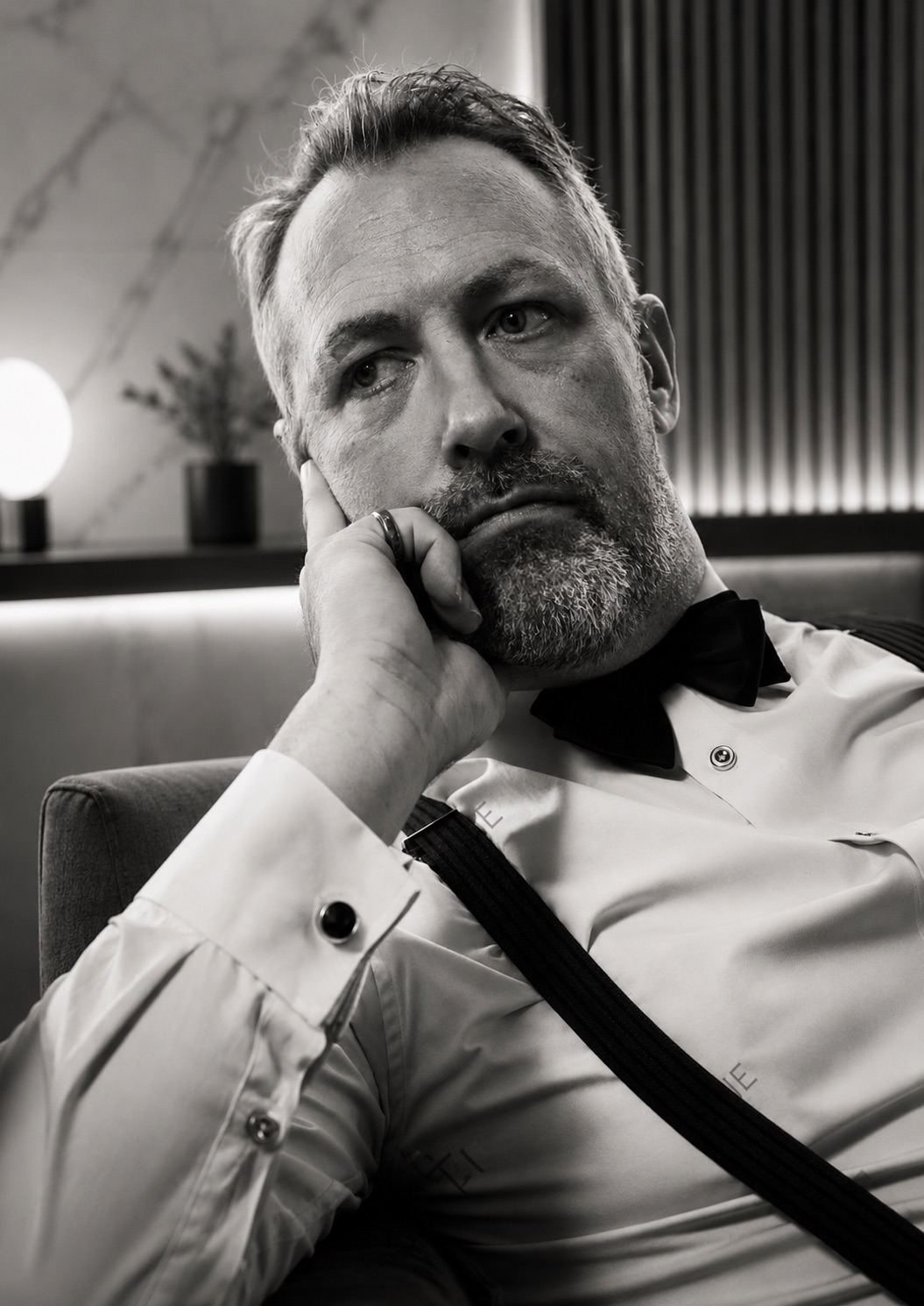 Black and white portrait of Wade Morgan in bow tie and suspenders, contemplative pose — Buzz-Music interview feature
